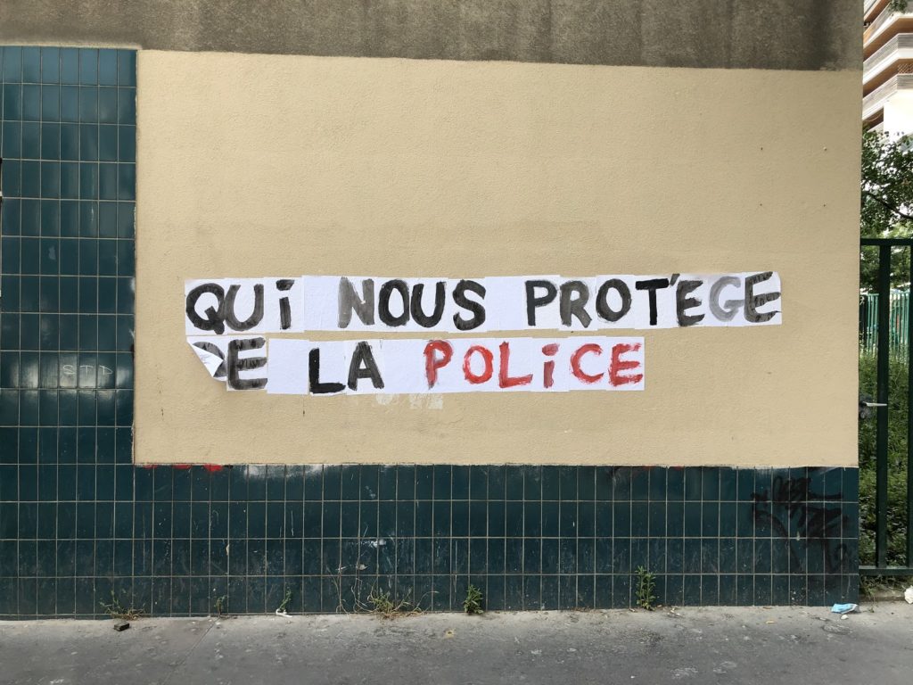 Collage du slogan "Qui nous protège de la police".