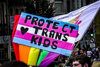 Une pancarte sur laquelle est marqué "protect trans kids"