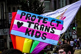 Une pancarte sur laquelle est marqué "protect trans kids"